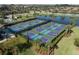 Aerial view of a community pickleball complex, showcasing multiple courts and surrounding greenery at 6715 Grand Estuary Trl # 203, Bradenton, FL 34212