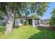 Lush backyard featuring an enclosed sunroom, a trampoline, and mature shade trees at 7330 Fairwood Ave, New Port Richey, FL 34653