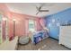 Colorful bedroom with pink and blue walls, complemented by a ceiling fan and wood look flooring at 7330 Fairwood Ave, New Port Richey, FL 34653