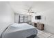 This bedroom features a ceiling fan, tile floors, window and TV at 7330 Fairwood Ave, New Port Richey, FL 34653