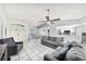 Bright living room with tile floors, ceiling fan, and comfortable gray seating at 7330 Fairwood Ave, New Port Richey, FL 34653