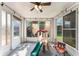 Enclosed sunroom with bright lighting, tile floors, and recreational equipment at 7330 Fairwood Ave, New Port Richey, FL 34653