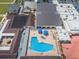 Aerial view of pool with umbrellas, chairs, and lounge seating located near parking and green space at 801 Oakmont Ave, Sun City Center, FL 33573