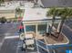 The atrium entrance is enhanced by palm trees and parking for golf carts and cars at 801 Oakmont Ave, Sun City Center, FL 33573
