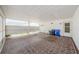 Covered carport area with ample space for parking, with garbage bins and a door to the side of the house at 801 Oakmont Ave, Sun City Center, FL 33573