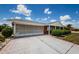 Angle shot of a home showing the driveway, screened garage, and brick exterior at 801 Oakmont Ave, Sun City Center, FL 33573