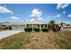 Well-kept single-Gathering home with charming landscaping and screened garage under a bright, blue sky at 801 Oakmont Ave, Sun City Center, FL 33573