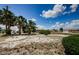 Charming front yard showcases lush palm trees and manicured bushes under a sunny sky at 801 Oakmont Ave, Sun City Center, FL 33573