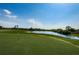 Picturesque view of a golf course green with a tranquil lake in the background, ideal for relaxation and recreation at 801 Oakmont Ave, Sun City Center, FL 33573