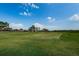 Expansive golf course fairway with a distant view of homes and trees, offering a serene and spacious setting at 801 Oakmont Ave, Sun City Center, FL 33573
