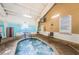 Inviting indoor spa with bubbling hot water and brick-paved surroundings, next to an entrance to the larger pool at 801 Oakmont Ave, Sun City Center, FL 33573