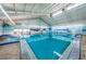 Bright indoor pool with multiple lanes and wall art and a hand rail for easing yourself into the water at 801 Oakmont Ave, Sun City Center, FL 33573