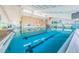 Indoor pool features blue water, lane dividers, and colorful decor, offers a refreshing aquatic experience for all at 801 Oakmont Ave, Sun City Center, FL 33573