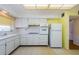 Efficient kitchen with white cabinets, appliances, tile floor, and bright natural light at 801 Oakmont Ave, Sun City Center, FL 33573