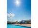 Community pool area with tables, umbrellas, lounge chairs, and clear blue sky in the background at 801 Oakmont Ave, Sun City Center, FL 33573
