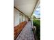 Covered walkway alongside a brick home, leading to the front entrance with white trim at 801 Oakmont Ave, Sun City Center, FL 33573