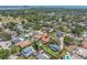 An aerial view featuring suburban homes, swimming pools, lush greenery, and distant water views at 8263 132Nd St, Seminole, FL 33776
