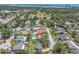 An aerial view showcasing homes with swimming pools and lush greenery, with a view of the ocean in the background at 8263 132Nd St, Seminole, FL 33776