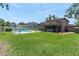 Backyard with a deck, screened patio, large sparkling pool, patio area, and expansive green lawn at 8263 132Nd St, Seminole, FL 33776