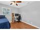 Well-lit bedroom with a ceiling fan, desk, and hardwood floors, perfect for work and relaxation at 8263 132Nd St, Seminole, FL 33776
