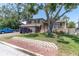 Inviting two-story home with a two-car garage, charming front porch, mature trees, and landscaped front yard at 8263 132Nd St, Seminole, FL 33776
