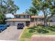 Charming two-story home with a large front yard, mature trees, a two-car garage, and a welcoming front porch at 8263 132Nd St, Seminole, FL 33776