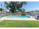 The backyard features a sparkling pool, patio area with lounge chairs, and lush green grass at 8263 132Nd St, Seminole, FL 33776
