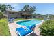 The backyard features a large pool, patio area with lounge chairs, and lush green grass at 8263 132Nd St, Seminole, FL 33776