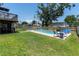 The backyard features a sparkling pool, patio area with seating, and lush green grass at 8263 132Nd St, Seminole, FL 33776