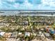 Beautiful aerial view of a residential area with waterfront access and lush greenery under a partly cloudy sky at 860 Bruce Ave, Clearwater Beach, FL 33767