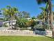 Beautiful home exterior featuring lush tropical landscaping, rock garden, and a well-manicured lawn at 860 Bruce Ave, Clearwater Beach, FL 33767