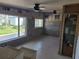 Partially renovated living room, featuring tiled floors, block walls, updated ceiling fans, and windows at 860 Bruce Ave, Clearwater Beach, FL 33767