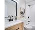 Bright bathroom featuring white subway tile, wood vanity and black hardware at 9097 Southern Comfort Dr, Largo, FL 33773