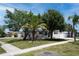 Attractive single-story home with lush landscaping, a green lawn, and a painted driveway at 9097 Southern Comfort Dr, Largo, FL 33773