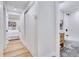 Hallway leading to a bathroom with patterned floors and wood vanity and bedroom with white comforter at 9097 Southern Comfort Dr, Largo, FL 33773