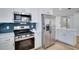 Close-up of a modern kitchen featuring stainless steel appliances, white cabinets, and stylish countertops at 9097 Southern Comfort Dr, Largo, FL 33773