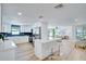 Open concept kitchen with stainless steel appliances, modern cabinetry and breakfast bar leading into a bright living area at 9097 Southern Comfort Dr, Largo, FL 33773