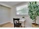 Bright office nook featuring a window with blinds, hardwood floors, and a white desk at 9097 Southern Comfort Dr, Largo, FL 33773