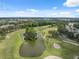 Panoramic aerial showcasing the lush golf course with a winding pond and sand traps at 9307 Golf View Dr, New Port Richey, FL 34655