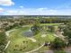 Picturesque aerial view of the golf course featuring a scenic pond and lush green landscaping at 9307 Golf View Dr, New Port Richey, FL 34655