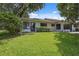 Exterior view of a well-maintained backyard with lush green grass, mature trees and a patio at 9307 Golf View Dr, New Port Richey, FL 34655