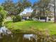 Spacious backyard featuring a tranquil pond view and lush green lawn at 9307 Golf View Dr, New Port Richey, FL 34655
