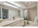 Bathroom with tub-shower combo, tile floors, and large mirror with accent wallpaper at 9307 Golf View Dr, New Port Richey, FL 34655
