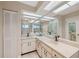 Bathroom with double sinks, marble countertops, large mirror, and tile floors at 9307 Golf View Dr, New Port Richey, FL 34655