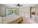 Bedroom with light wood floors, ceiling fan, and sliding glass doors to the screened porch at 9307 Golf View Dr, New Port Richey, FL 34655