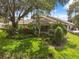 Charming home exterior with lush landscaping and mature trees, offering shade and privacy at 9307 Golf View Dr, New Port Richey, FL 34655
