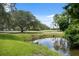 Scenic golf course view with a tranquil pond, lush greenery, and mature trees at 9307 Golf View Dr, New Port Richey, FL 34655