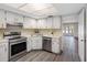 Well-lit kitchen with stainless steel appliances and white cabinets; view into living space at 10356 Carrollwood Ln # 204, Tampa, FL 33618