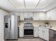 Bright kitchen features stainless steel appliances, white cabinets, and a double sink at 10356 Carrollwood Ln # 204, Tampa, FL 33618