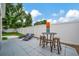 Patio area with outdoor bar-height table, lounge chairs, and lawn at 10664 Starkey Rd, Seminole, FL 33777